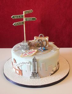 a birthday cake decorated with street signs, luggage and other things to travel around the world