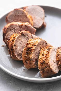 sliced meat on a white plate sitting on a table