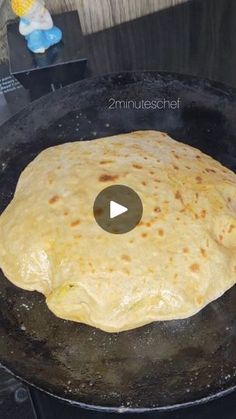 an uncooked tortilla being cooked in a cast iron skillet