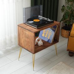 an old record player is sitting on top of a wooden table with hairpin legs