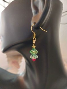 Crystal Lily Shaped bead Christmas Tree Earrings that come in two variations, silver and gold toned stars. ⚬ Free shipping on all orders $35 or above ⚬ Each piece is handmade ⚬ Made in the USA. ⚬ More in our shop: https://www.etsy.com/shop/BellaLilahJewelry QUESTIONS? Please feel free to message me anytime! I'd love to hear it and I'm ready to answer all of your questions! Thank you for visiting Bella Lilah. Handmade Gold Christmas Earrings, Nickel-free Festive Jewelry, Holiday Gold Beaded Jewelry, Handmade Gold Earrings For Christmas, Handmade Jewelry For Holiday Celebration, Handmade Holiday Jewelry For Celebration, Beaded Dangle Christmas Jewelry, Green Dangle Christmas Jewelry, Christmas Beaded Dangle Jewelry