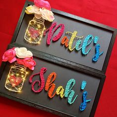 two framed signs that say happy sale and have flowers in mason jars with lights on them