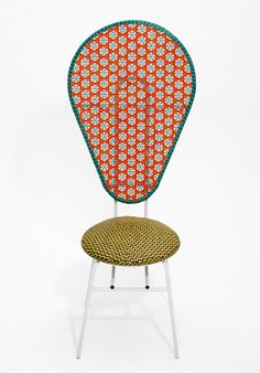 an orange and green chair with a white frame on it's back end, against a white background