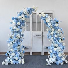 blue and white flowers are arranged in an arch