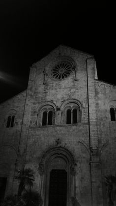 an old building with a clock on it's face and windows at the top