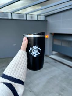 a person holding a starbucks cup in their hand