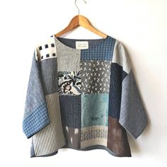 a patchwork sweater hanging on a wooden hanger