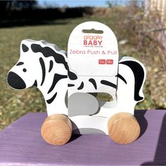 a wooden zebra toy sitting on top of a purple table