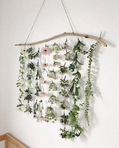 a wall hanging with flowers and greenery on it