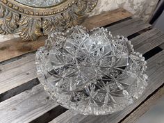 a glass dish sitting on top of a wooden pallet next to a wall mirror