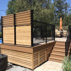 a wooden deck with black railing and steps