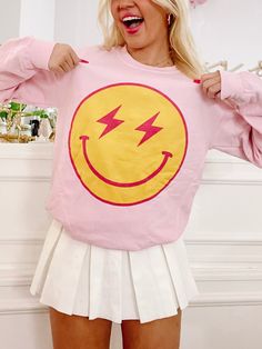 Our Striking Smiles Crewneck is a light pink pretty that is super soft inside! The front has a large smiley face with lightning bolt eyes. Also available in a tee. Trendy Fall Tops With Smiley Face, Trendy Smiley Face Tops For Fall, Trendy Fall Smiley Face Tops, Fun Pink Tops With Smiley Face, Trendy Smiley Face Loungewear Tops, Trendy Smiley Face Tops For Loungewear, Fun Pink Smiley Face Tops, Cute Pink Smiley Face Top, Trendy Pink Smiley Face Tops