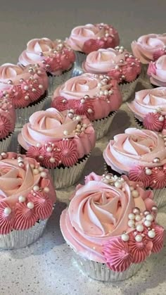 several cupcakes with pink frosting and flowers on them