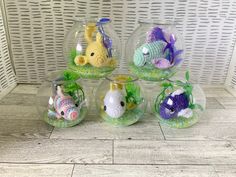 four fish in small glass bowls sitting on the floor