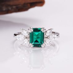 Few color schemes have a more sophisticated and luxurious feel than the iconic pairing between silver and emerald green – and this is a style we’ve captured in our stunning Ivy ring design. Simplistic yet beautiful, our Emerald ivy ring features a massive, 2.0-carat emerald as the main center, while six striking CZ crystals transform the look and create an unrivaled level of sophistication overall. ✦ DETAILS ✦✧ Handcrafted ✧ 2.0 Carat center stone✧ Emerald and cz crystals ✧ Sizes 3.75-11.25✧ Thi Silver And Emerald Green, Ivy Ring, Rose Gold Emerald Ring, Timeless Ring, Ring Rose Gold, Emerald Stone, Emerald Ring, Silver Roses, Silver Rose Gold