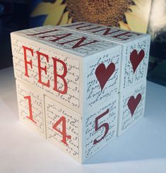 a white cube with red letters and hearts on it