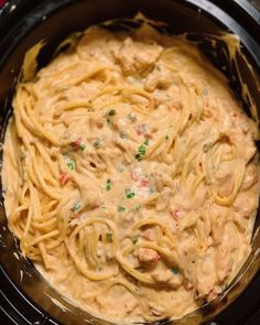 a crock pot filled with pasta and meat in cream sauce, ready to be cooked