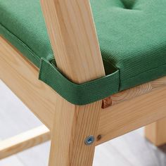 a wooden chair with a green cushion on it