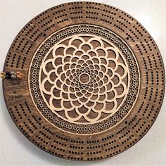 an intricately designed wooden plate on a white surface