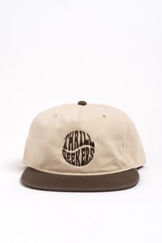 The Twist Hat offers a comfortable fit and steezy simple look. This cap's unstructured 5 panel fit makes it super duper comfy. Offered in a neutral two-tone off white / brown with the Thrill Seekers Twist logo embroidered in a matching brown. Features Mid Profile, Five Panel Cap Snapback Light-weight, Semi-Structured Fit 100% cotton construction with a plastic snapback Beige Snapback Baseball Cap For Outdoor, Beige Snapback Hat For Outdoor, Beige Snapback Cap For Outdoor, Casual Cream Six-panel Baseball Cap, Beige Snapback Hat With Flat Bill For Outdoor, Beige Snapback Trucker Hat For Outdoor, Adjustable Beige Snapback Hat For Outdoor, Brown Trucker Cap For Everyday, Brown Cotton Fitted Cap