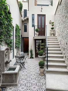 an outdoor courtyard with stairs and potted plants