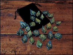 several pieces of metal with green leaves on them sitting on a wooden table next to a black bag