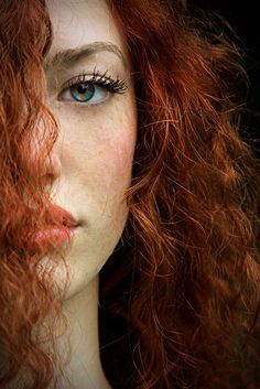 a woman with red hair and blue eyes