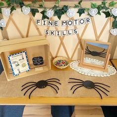 a wooden table topped with lots of fake spider legs next to a box filled with sprinkles