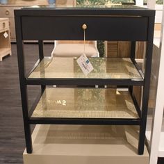 a black and gold display case with two shelves on each side that has a price tag hanging from the top