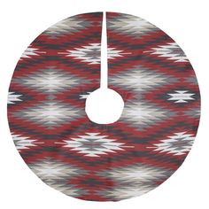 a red and white circular rug with an abstract design on it's side, hanging from