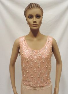 Beaded Blouse 50s Sequin Wiggle Top Pink Wool Sleeveless Shell Christmas Holiday Party Separates Vintage Size S 1950s Beautiful and shiny pink sleeveless shell perfect for holiday, party or casual wear Blouse is fully lined, has back metal zipper closure, bead dangles and is generously covered in iridescent sequins. Size S fabric has some stretch approximate measurements Bust underarm to underarm- 36 inches Waist- 34 inches Shoulder to shoulder-14.5 inches Length shoulder to hem-20 inches Has ma Fitted Pink Tank Top For Party, Pink Holiday Party Tops, Vintage Sleeveless Sequin Top, Spring Beaded Tank Top For Party, Spring Party Beaded Tank Top, Elegant Pink Evening Tank Top, Elegant Pink Tank Top For Evening, Festive Sleeveless Holiday Top, Elegant Pink Tops For Party Season