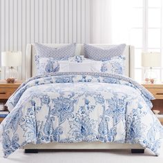 a bed with blue and white comforters in a room