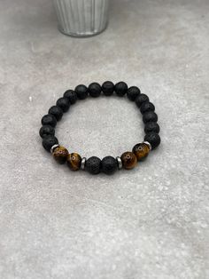 "Elevate your style with our Lava Stone & Tiger Eye Bracelet, featuring luxurious sterling silver spacers. Perfect blend of natural beauty and chic design." Crafted with care and precision, this bracelet features a durable stretch design, ensuring a comfortable fit for all wrist sizes. The 8mm beads are sized for both comfort and impact, making the bracelet substantial yet unobtrusive. This thoughtful design allows for easy wearing and removal, ideal for those who appreciate both style and conve Spiritual Black Beaded Bracelets With Stones, Black Lava Stone Beaded Bracelets With Natural Stones, Black Bracelets With Natural Stones For Everyday, Spiritual Black Bracelets With Stones, Black Lava Stone Bracelets With Gemstone Beads, Lava Stone Beaded Bracelet Jewelry, Black Lava Stone Bracelet With Gemstone Beads, Black Beaded Lava Stone Jewelry, Black Beads Lava Stone Jewelry