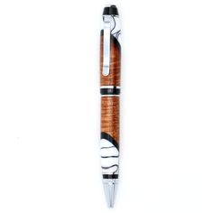 a pen that is sitting on top of a white surface with black and white designs