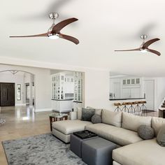 a living room filled with furniture and a ceiling fan in the middle of the room