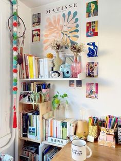 there are many books on the shelves and vases in this room, all decorated with colorful pom - poms