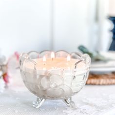 a glass bowl with candles in it sitting on a table