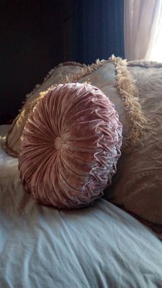 two pillows on top of a bed next to a window