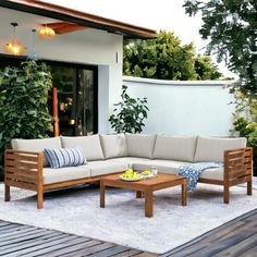 an outdoor living area with wooden furniture and plants