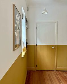 an empty hallway with yellow walls and wooden floors