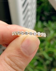 a person holding a diamond ring in their hand