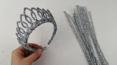 someone is making a tiara out of silver beads