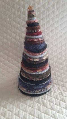 there is a small christmas tree made out of old sweaters on the bedding