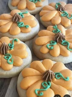 some cookies with icing on them are decorated like pumpkins and green ribbones