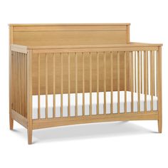 a wooden crib with white sheets on the bottom and side rails, against a white background