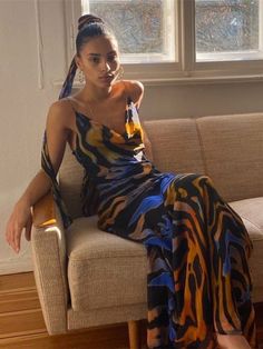 a woman sitting on top of a couch next to a window