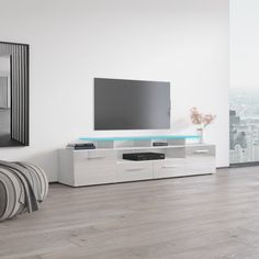 a living room with a large flat screen tv on top of a white entertainment center