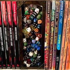 there are many different colored dices in this book case on the bookshelf