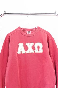 an oxa sweatshirt hanging on a clothes rack