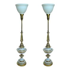 a pair of brass and glass candlesticks with shades of blue on the top